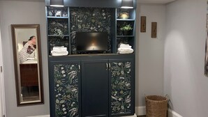 A bedroom with a bed, a wardrobe with floral designs, a television, and a mirror. - Family Friendly 3 bedroom close to downtown Raleigh (Raleigh)