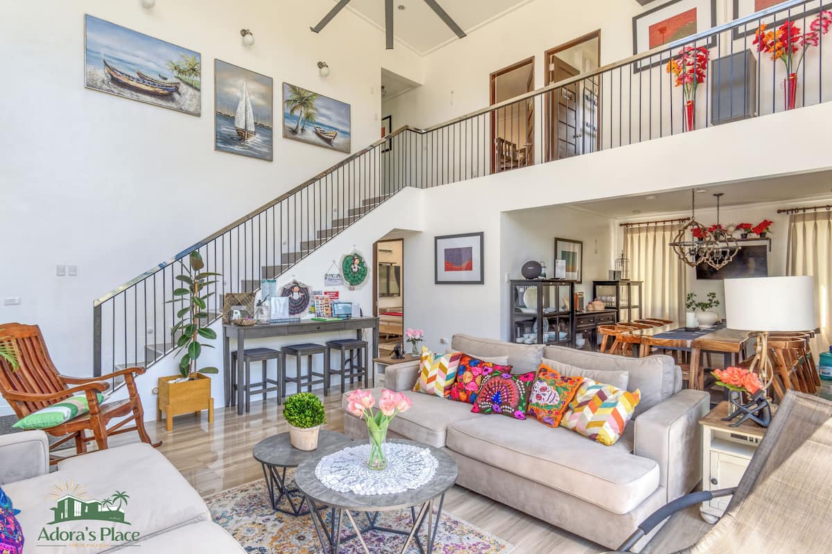 A spacious living area with a staircase, a dining area, and a kitchen.