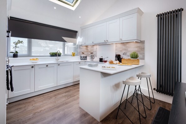 Enjoy cooking in this kitchen with a sleek island, bar stools, and ample counter space.