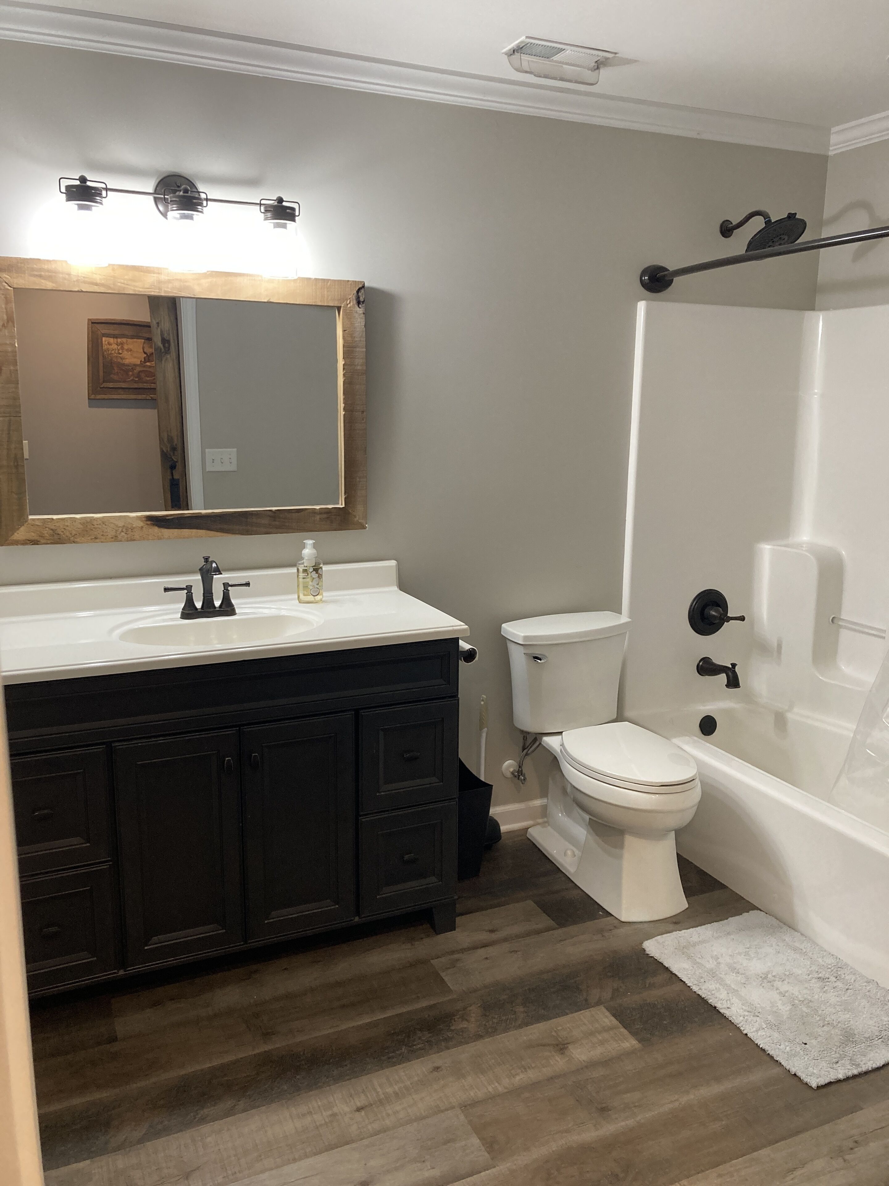 A bathroom with a white vanity, a toilet, and a bathtub.