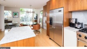 Una cocina moderna con armarios de madera, electrodomésticos de acero inoxidable y una isla central.
