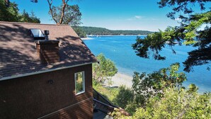 Uma casa de tijolos com vista para um lago e floresta.