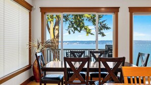 A dining area with a view of a body of water and trees, featuring a table and chairs. - Cascade View Haven by Avantstay Saratoga Vistas (Langley)