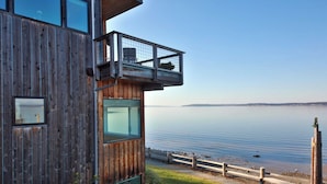 Ein Holzgebäude mit einem Balkon mit Blick auf einen ruhigen See.