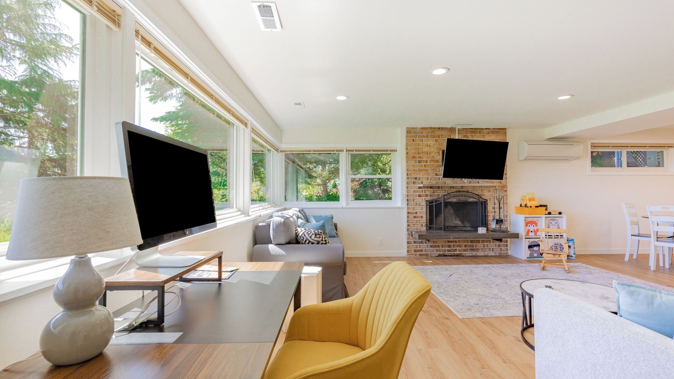 A modern living room with a fireplace, a flat-screen TV, and a sofa.