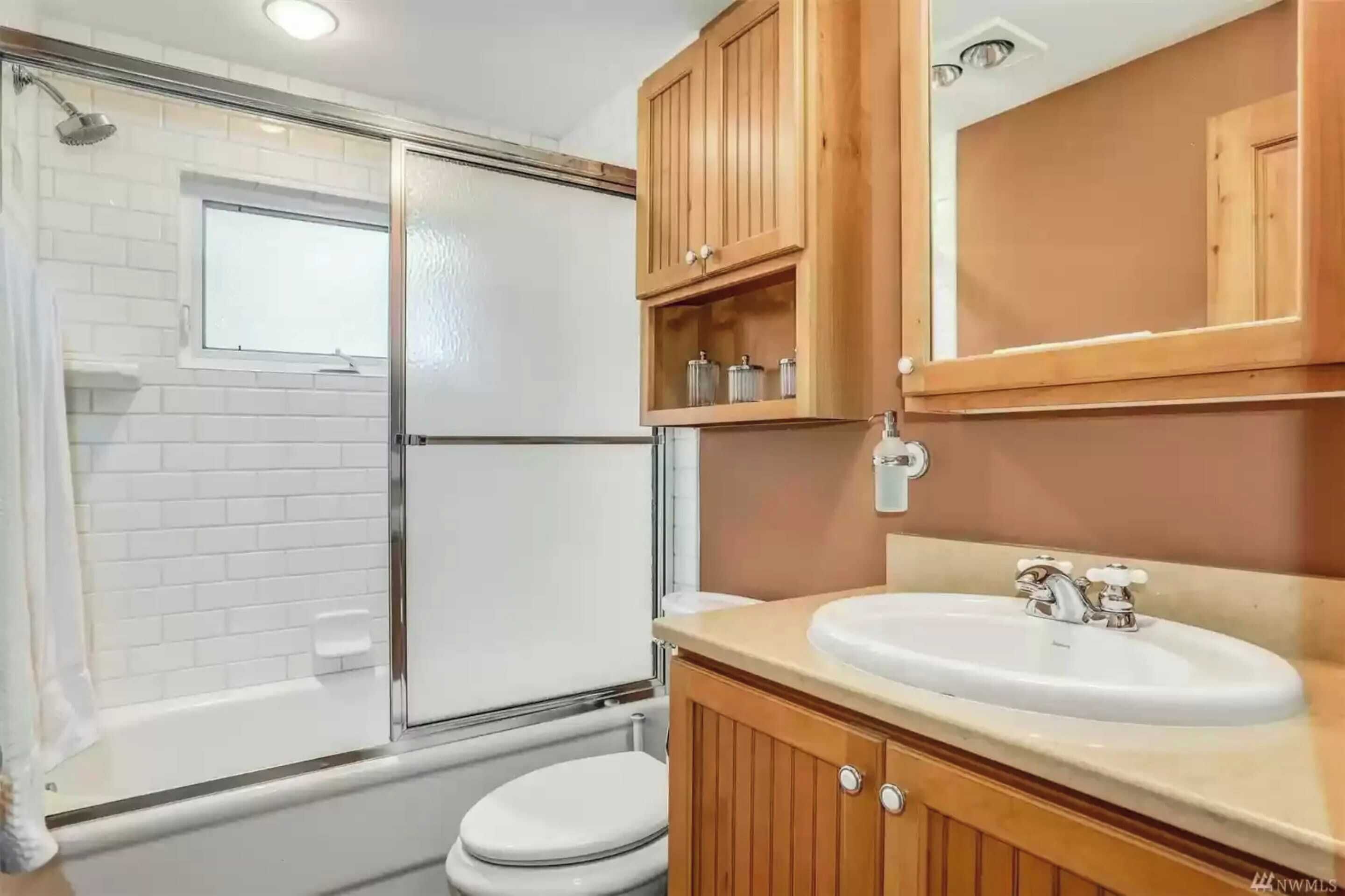 A bathroom with a shower, toilet, and sink.