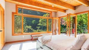 A bedroom with a large window, a bed, and a bench. - Rhythm Waters by Avantstay Garden Paradise, Pond (Langley)
