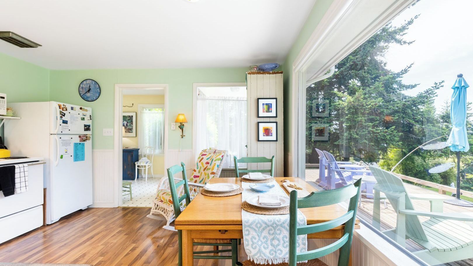 A dining area with a wooden table, chairs, and a view of the outdoors.
