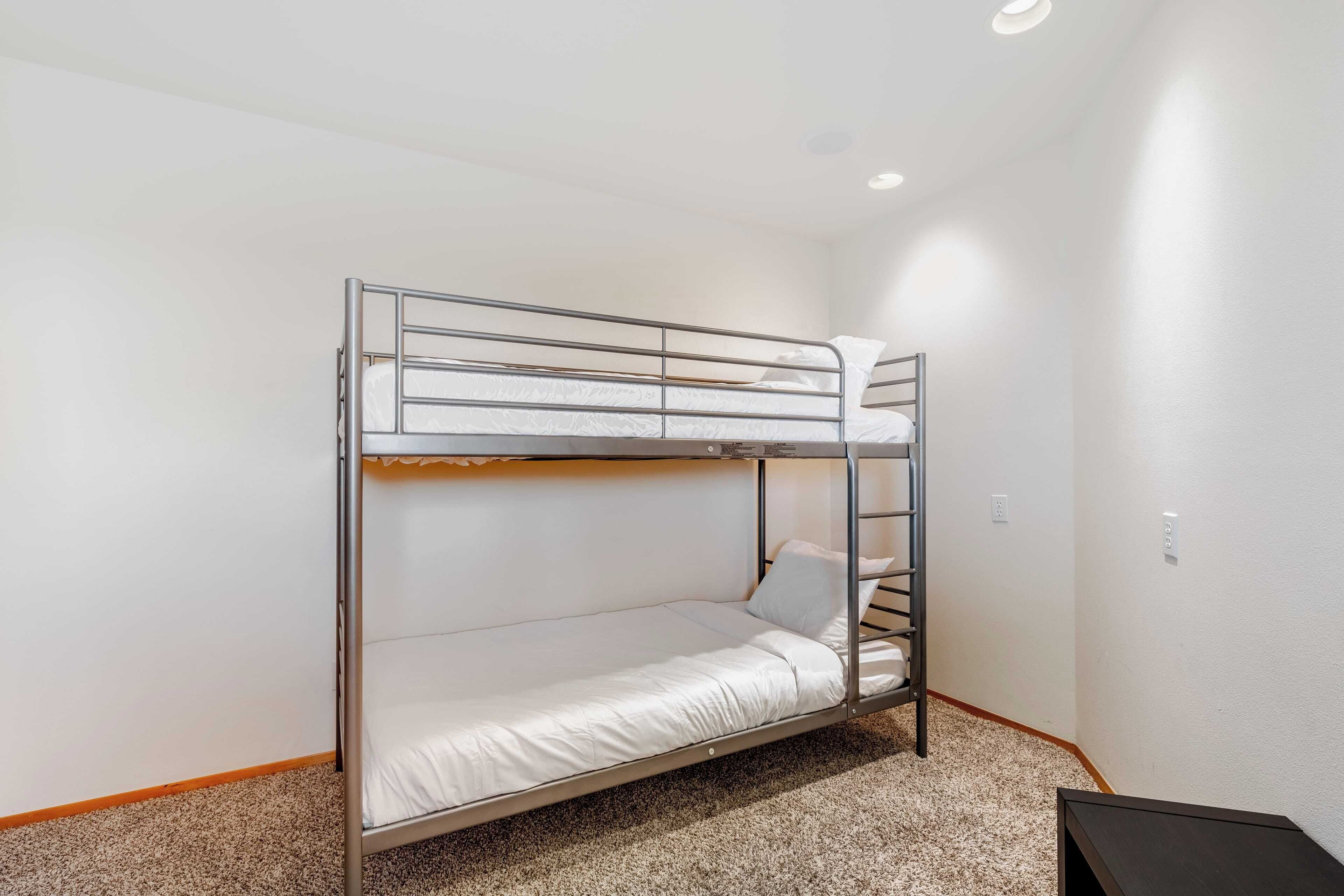 A bunk bed in a room with white walls and carpeted floor.