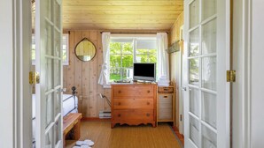 Un baño pequeño con tocador de madera, un lavabo, un espejo y una ventana con cortinas.