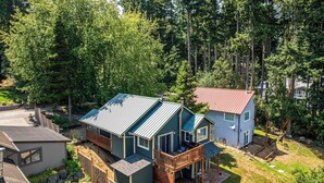 A residential property with a main house featuring a deck and a smaller attached structure.