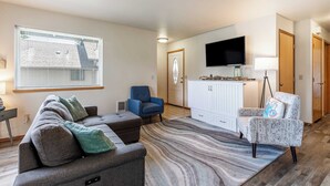 A living room with a grey sofa, blue armchair, and patterned rug.
