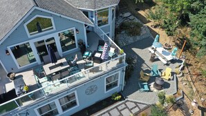 A two-story house with a balcony, outdoor seating area, and a stone pathway. - Fairway Harbor View by Avantstay Outdoor Oasis (Freeland)