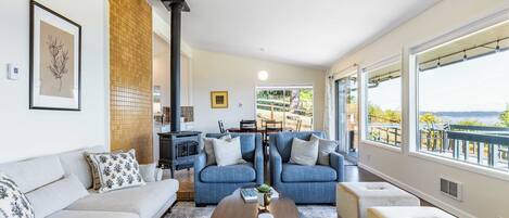 Un salon moderne avec un canapé, deux fauteuils bleus, une table basse et une cheminée.