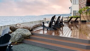 A wooden deck with outdoor seating and a view of the water. - Oceanfront w/ Game Room, Fire Pit, Panoramic Views Angels Landing by Avantstay (Langley)