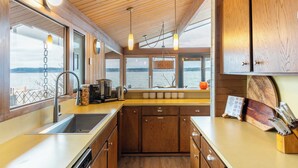 A kitchen with wooden cabinets, a stainless steel sink, and pendant lights. - Oceanfront w/ Game Room, Fire Pit, Panoramic Views Angels Landing by Avantstay (Langley)