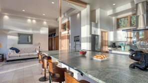Una cocina amplia con una isla grande, electrodomésticos modernos y vistas al exterior.
