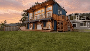 A two-story house with a deck, a staircase, and a garage. - Chateau Coho by Avantstay Easy Beach Access (Greenbank)