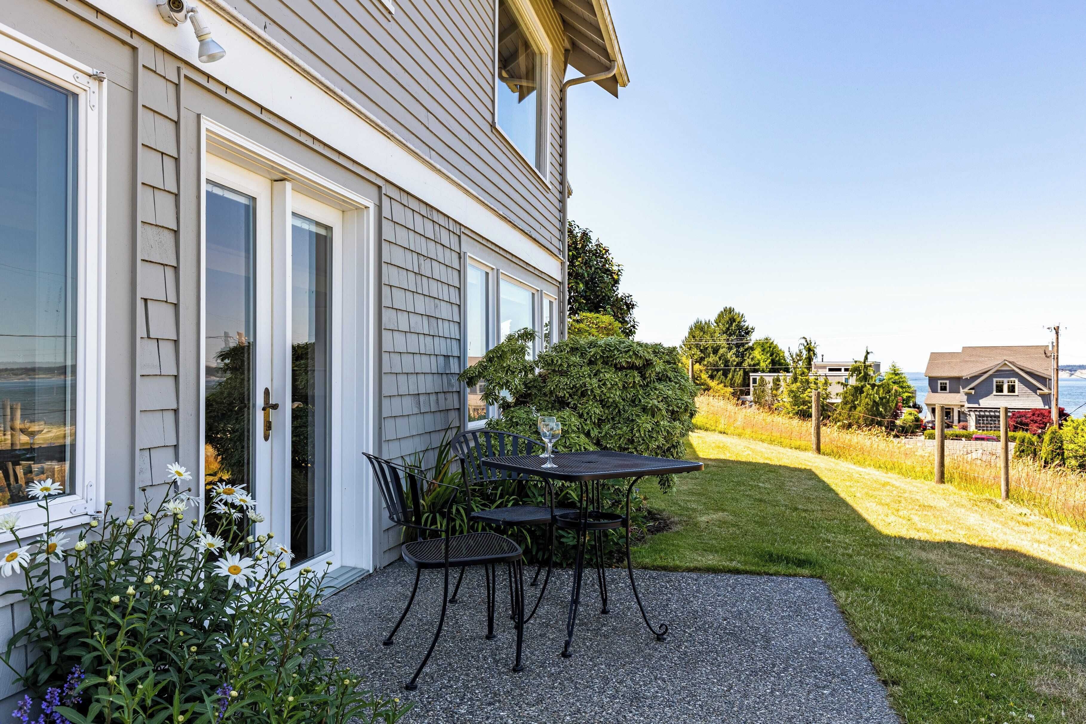 Une maison avec un patio, une table et des chaises.