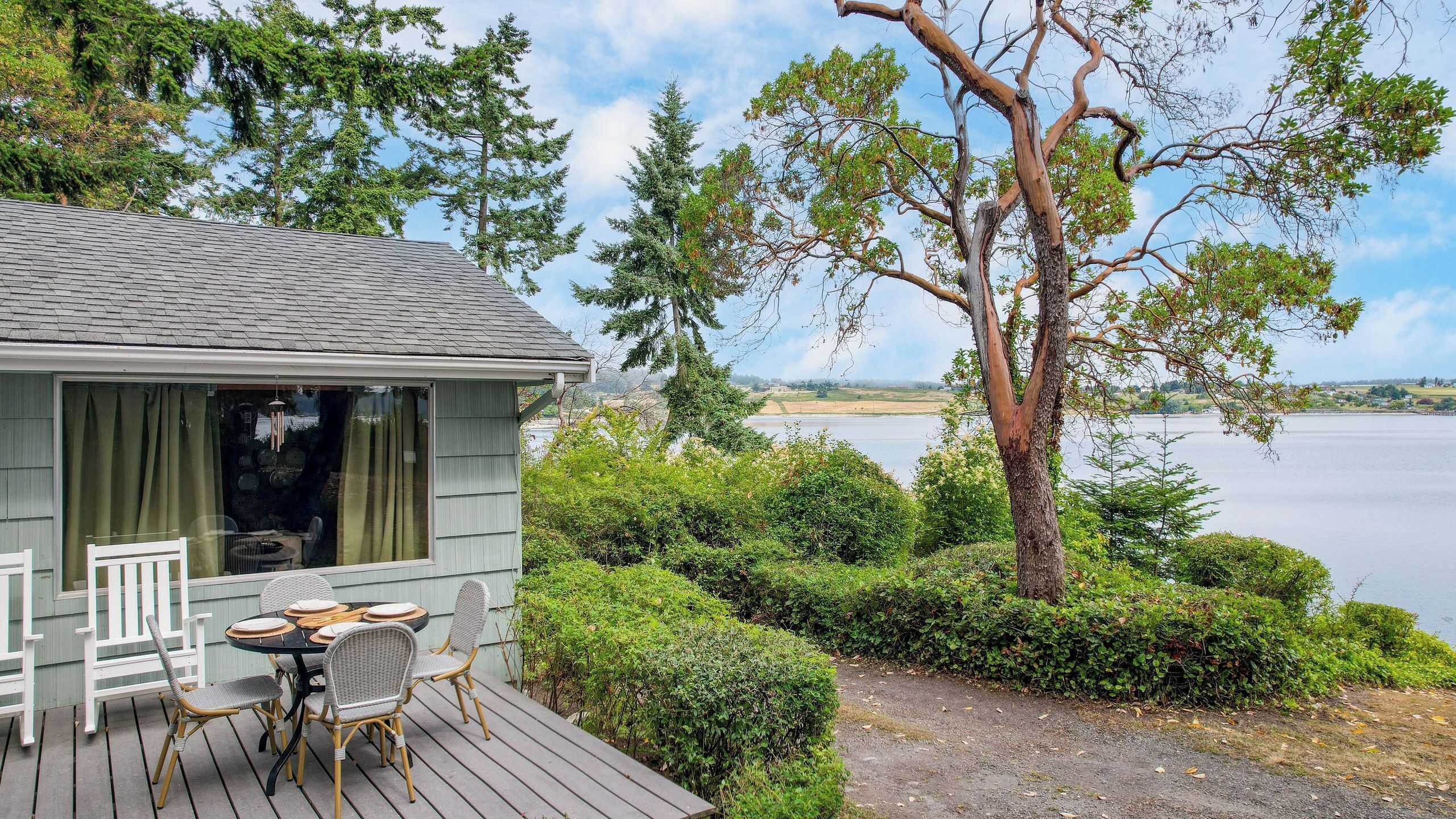 Een vakantiehuis aan het meer met terras, eettafel en stoelen.