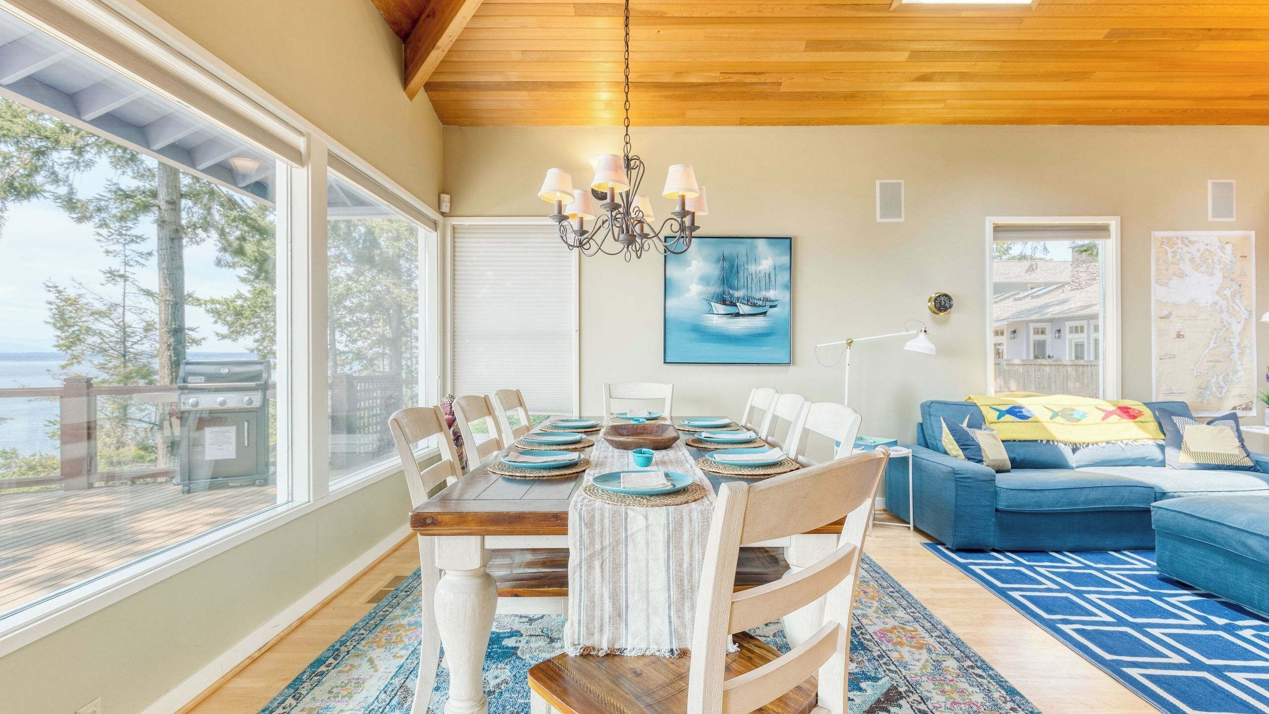 A dining area with a wooden table, chairs, and a chandelier.