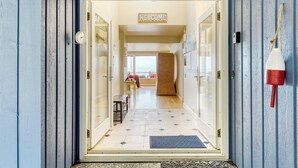 A hotel entrance with a 'WELCOME' sign, a bench, and a view of the interior. - Barranco by Avantstay Stairway to Beach + Views (Greenbank)