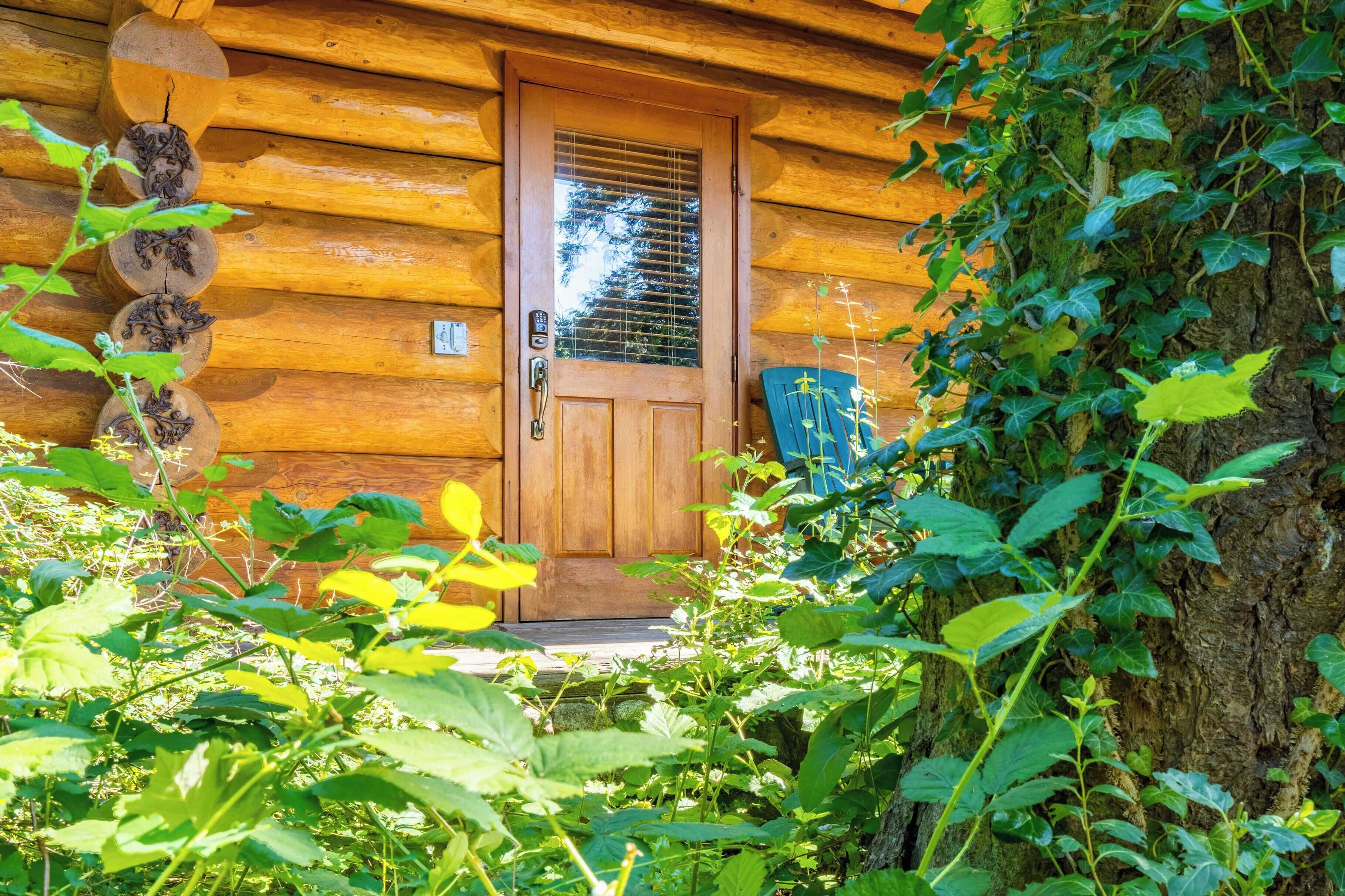 Una cabaña de madera con puerta de madera y un pequeño porche.