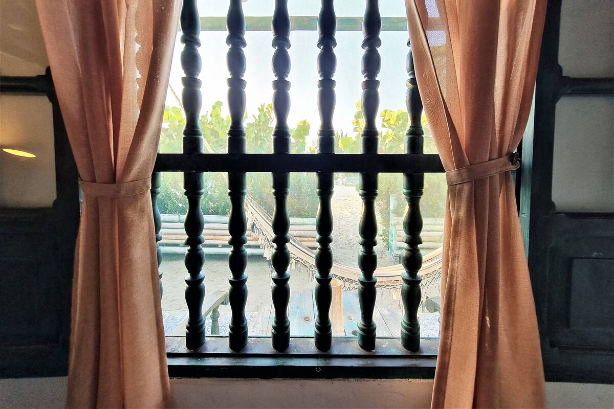 Une fenêtre dotée d’une balustrade en bois et de rideaux.