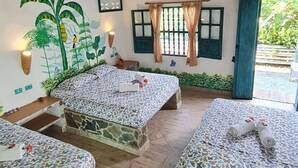 Ein Zimmer mit drei Betten, Holzbalkendecke, Wandgemälde und einem Fenster mit Vorhängen.
