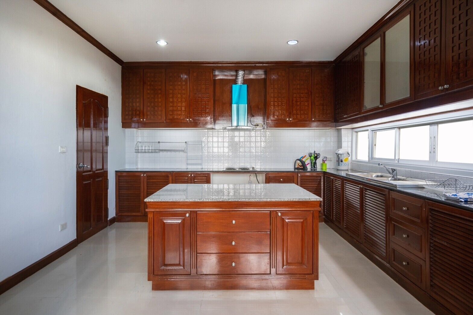 A kitchen with wooden cabinets, a central island, and a window.
