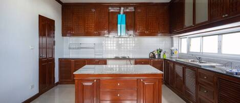 A kitchen with wooden cabinets, a central island, and a window.