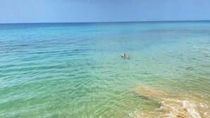 A clear view of a beach with calm waters and a distant shoreline. - Aguas Azules Villa 1 On Corcega BEACH with POOL (Calvache)