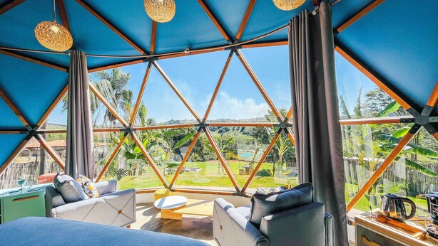 A spacious room with a large window, a sofa, a small table, and hanging lights. - Rua José Joaquim Nogueira (Santa Branca)