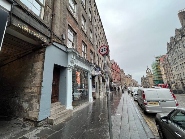 A street with buildings, a speed limit sign, and parked cars.