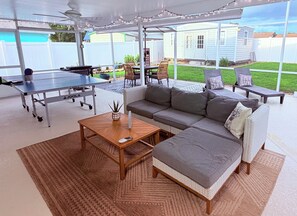 An outdoor patio with a ping pong table, a sofa, and a dining table. - Casa Bohemian Retreat (Tavares)