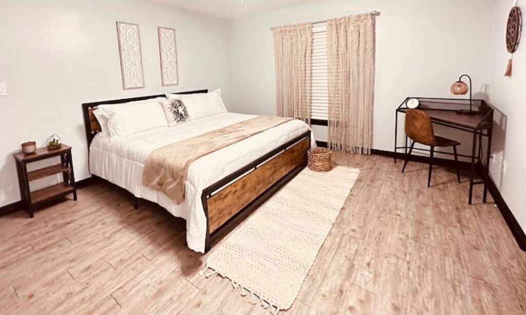Une chambre à coucher avec un lit en bois, un bureau et une chaise.
