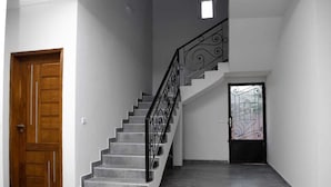 A staircase with a black metal railing and a wooden door at the bottom. - Cap Skirring (Cap Skirring)