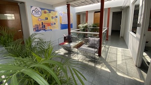 A hotel corridor with a glass railing, potted plants, and a map on the wall.