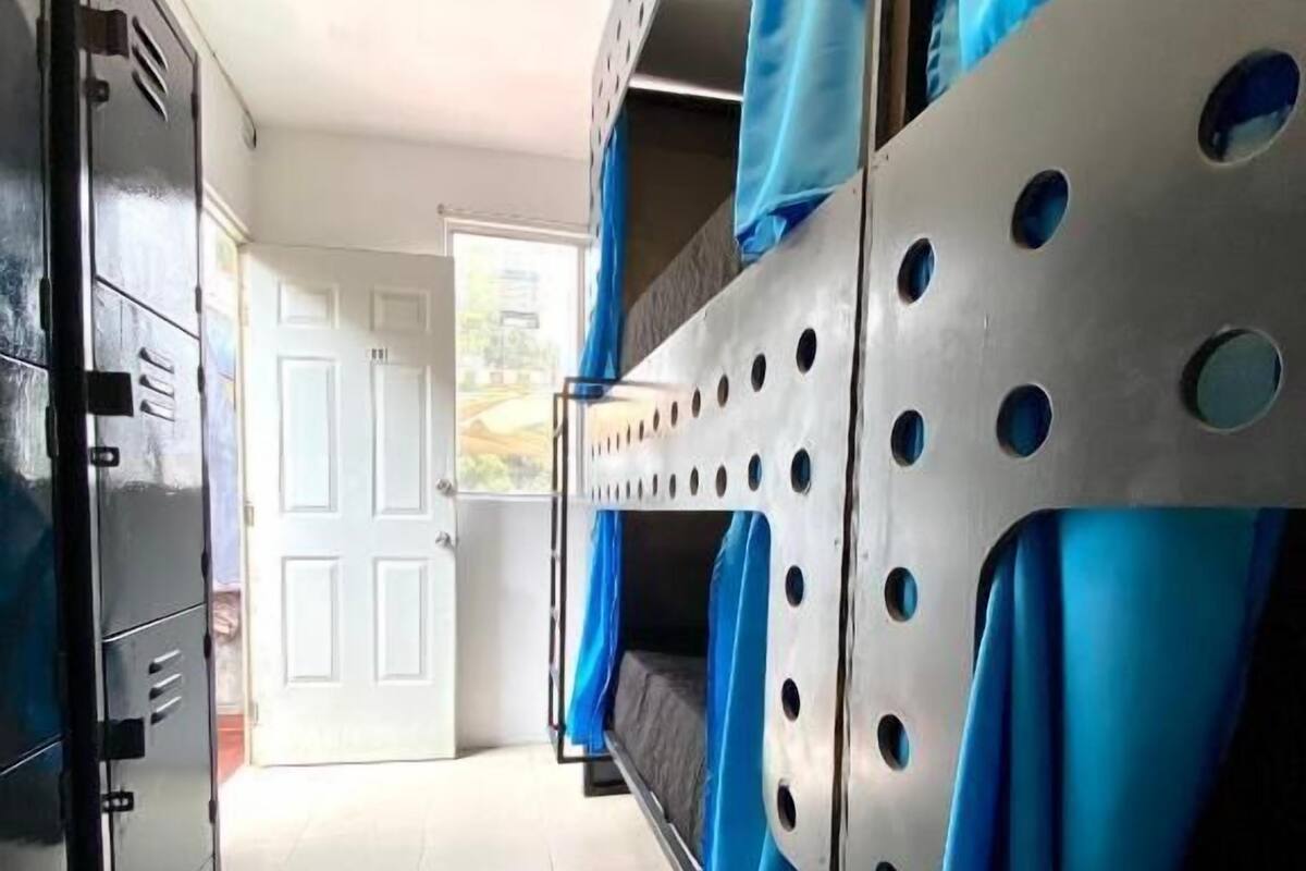 Ein Zimmer mit Etagenbetten, einem Kleiderschrank und einer Tür, die nach draußen führt.