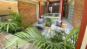 A modern interior with a glass atrium, brick walls, and indoor plants.