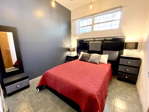 A bedroom with a large bed, a nightstand, a dresser, a mirror, and a window with curtains. -  RMS Hostal - Reforma (Mexico City)