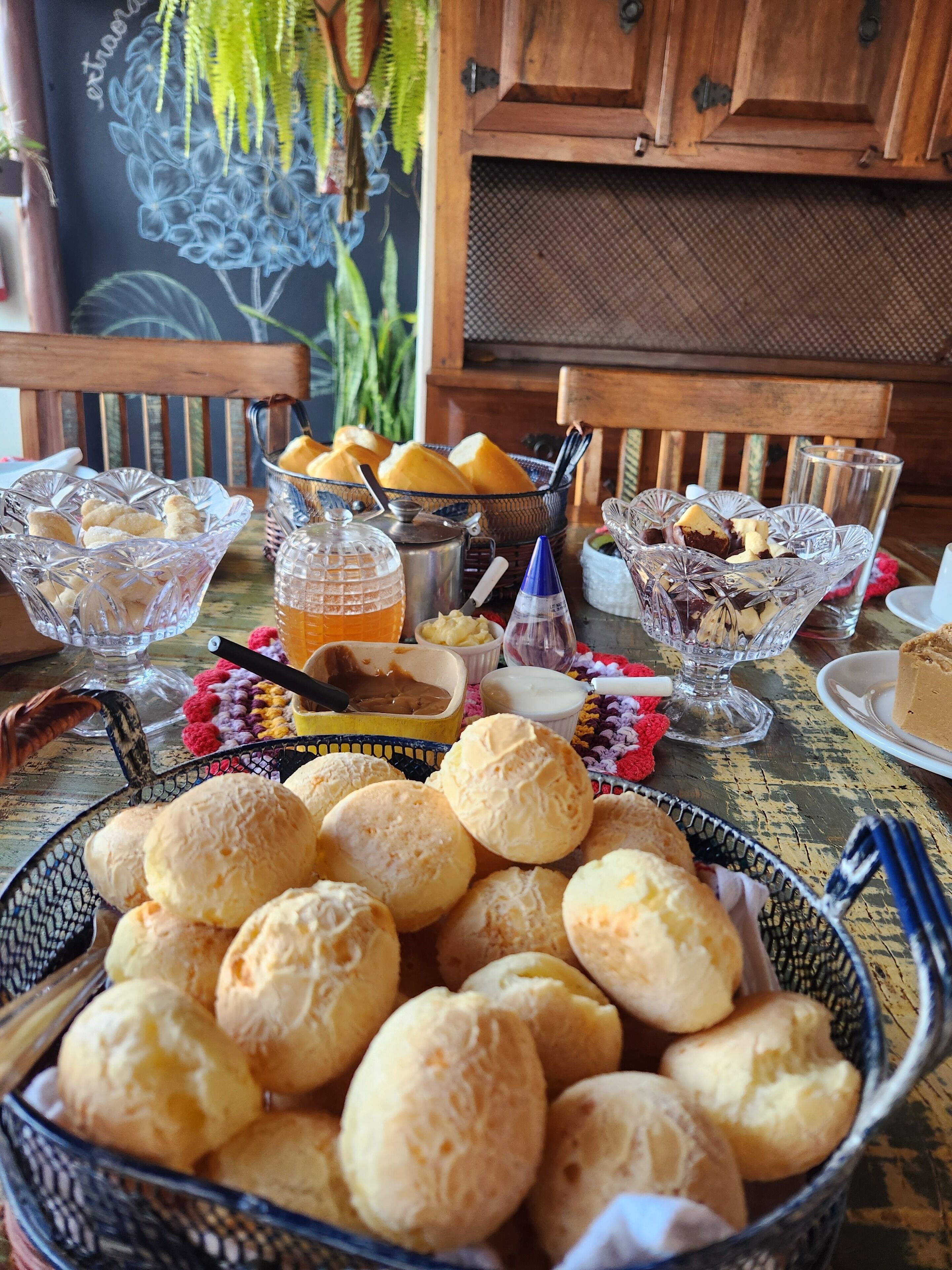 Una mesa con diversos alimentos, entre ellos pan, pasteles y una bebida.