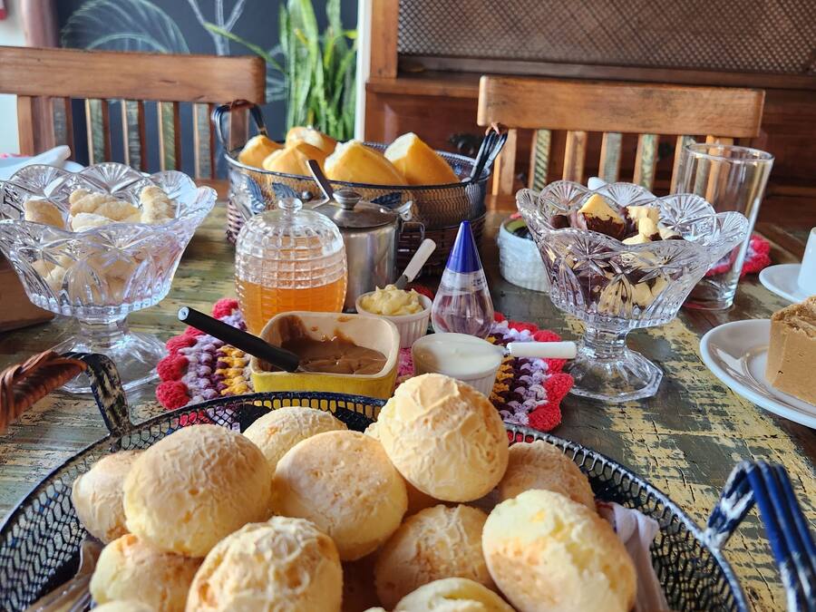 Una mesa con diversos alimentos, entre ellos pan, pasteles y una bebida.