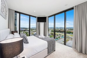 Enjoy expansive city views from the comfort of a large bed against floor-to-ceiling windows.