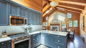 A kitchen with grey cabinets, a stainless steel stove, and a microwave.