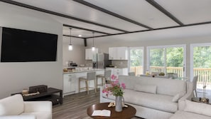 Un salon moderne avec un canapé, une table basse et un téléviseur fixé au mur.