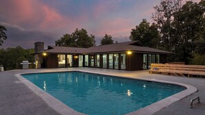 A modern house with a swimming pool, large windows, and a stone chimney. - Amber Refresh by Avantstay Pool and Hot Tub (New Market)