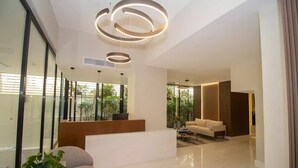 Uma sala de estar moderna com um sofá, mesa de centro e uma planta em vaso.