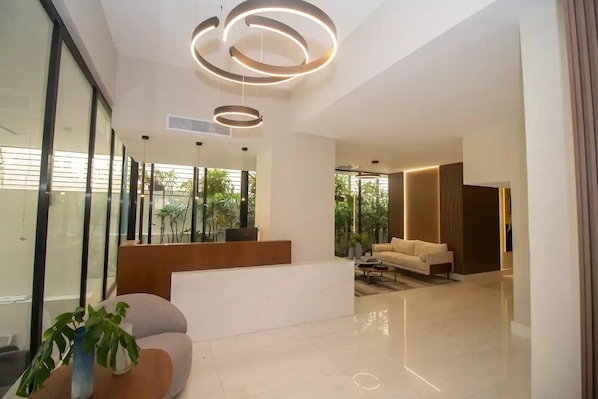 A modern living room with a sofa, coffee table, and a potted plant.