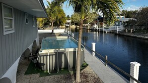 A house with a pool, a palm tree, and a dock extending into a body of water. - FISHERMANS DREAM HOUSE (Big Pine Key)